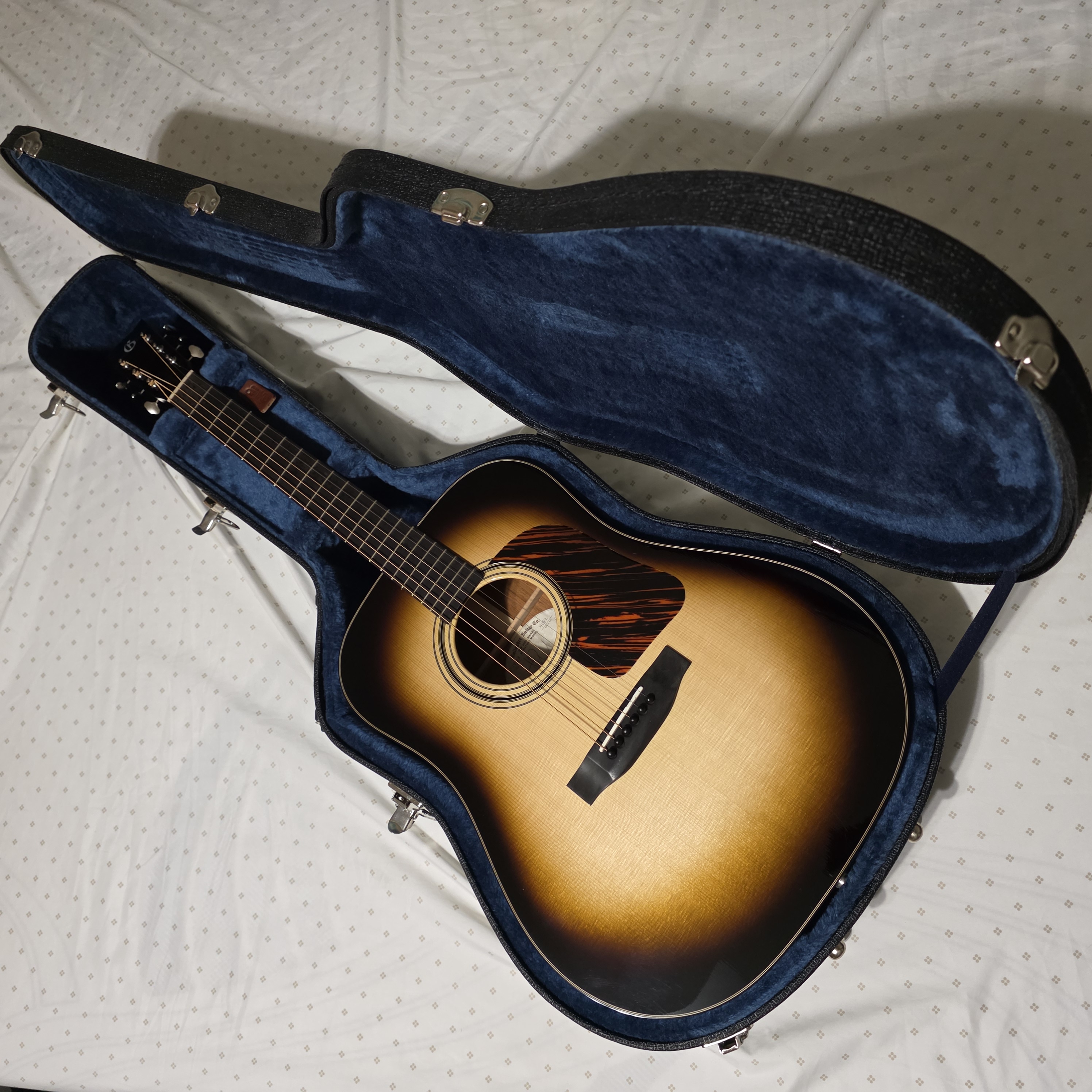 Sunburst acoustic guitar in a case